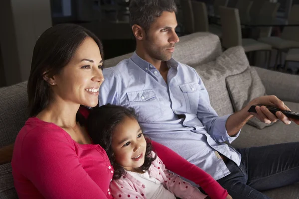 Rodzina siedzi na kanapie i oglądać telewizję — Zdjęcie stockowe