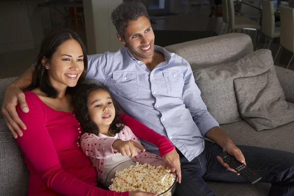 Famiglia seduta sul divano e guardando la TV — Foto Stock