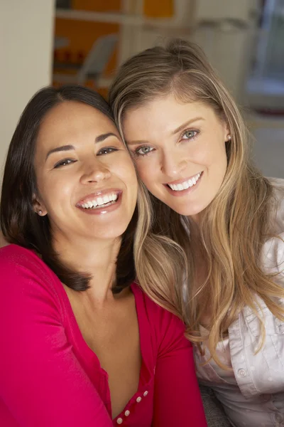 Sonrientes amigas en el sofá — Foto de Stock