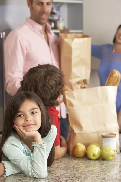 Família desembalar compras de supermercado na cozinha — Fotografia de Stock