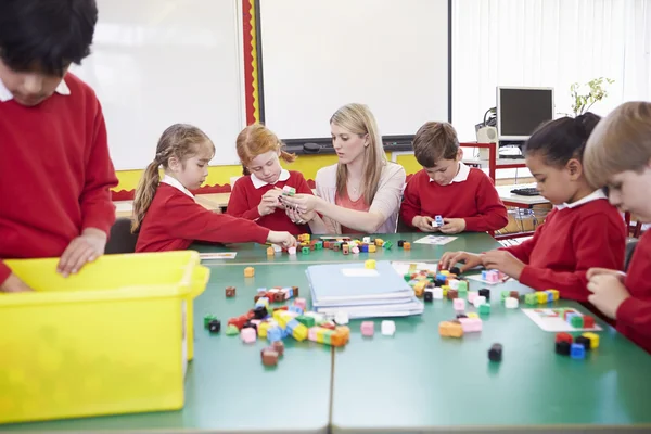 Schüler und Lehrer arbeiten mit farbigen Blöcken — Stockfoto