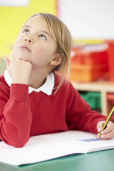 Grundschülerin arbeitet am Schreibtisch — Stockfoto