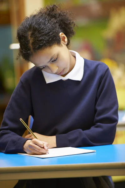 Livre d'écriture d'élève d'école femelle en salle de classe — Photo