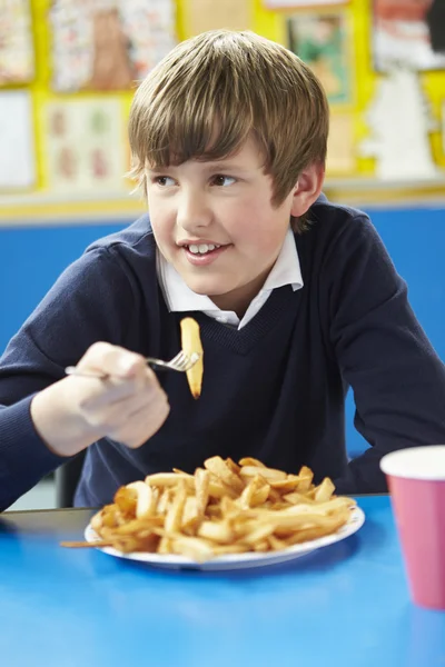 男学生吃不健康的学校午餐 — 图库照片