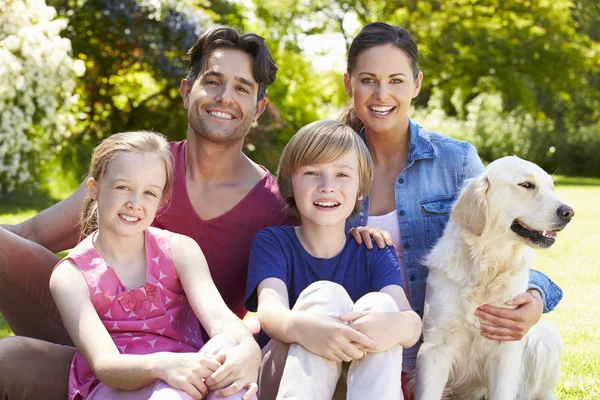 Familj med hund koppla av i trädgården — Stockfoto