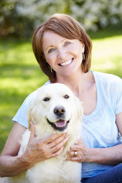 Зрелая женщина, сидящая с собакой — стоковое фото