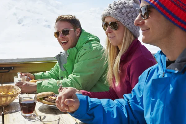 Vrienden genieten van de maaltijd in skigebied — Stockfoto