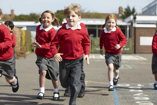 Elementary School Pupils Running In Playground Royalty Free Stock Images