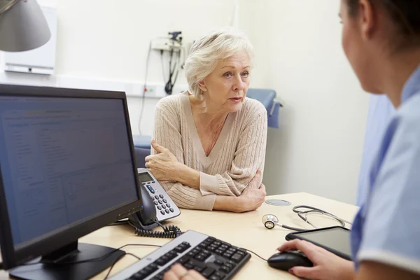 Senior patiënt heeft een afspraak met de verpleegkundige Rechtenvrije Stockfoto's