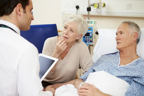 Medico parlando con coppia da ospedale letto — Foto Stock