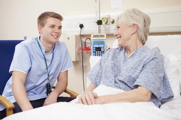 Infirmière assise près du lit du patient à l'hôpital — Photo