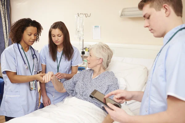 Stagiair verplegend personeel door Bed van de patiënt — Stockfoto