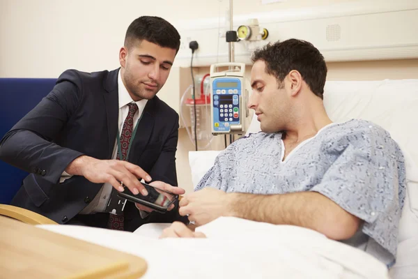 Docteur assis près du lit du patient avec tablette numérique — Photo