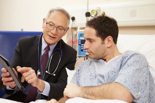 Dokter zitten door patiënt Bed met digitale Tablet — Stockfoto