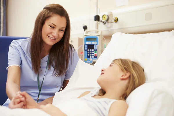 坐在医院的女孩的床边的护士 — 图库照片