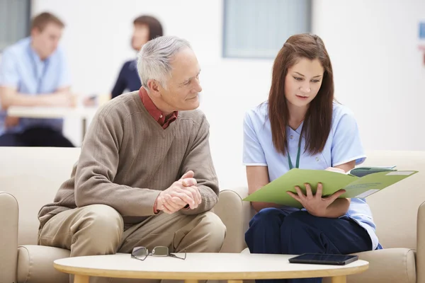 Senior Man diskutera resultat med sjuksköterska — Stockfoto