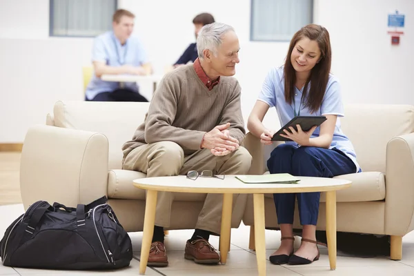 Senior Man diskutera resultat med sjuksköterska — Stockfoto