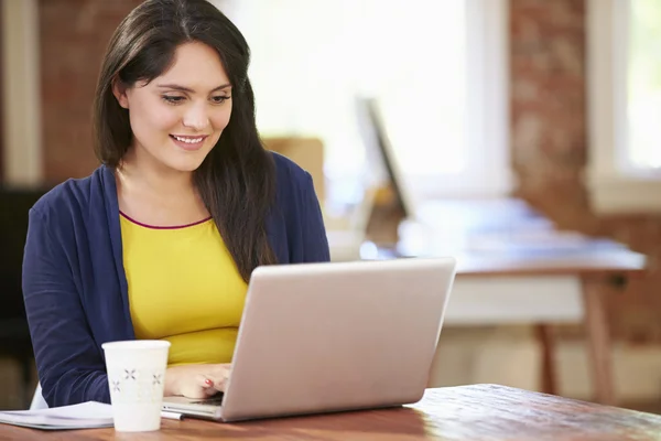 Kobieta pracuje na laptopie w biurze — Zdjęcie stockowe