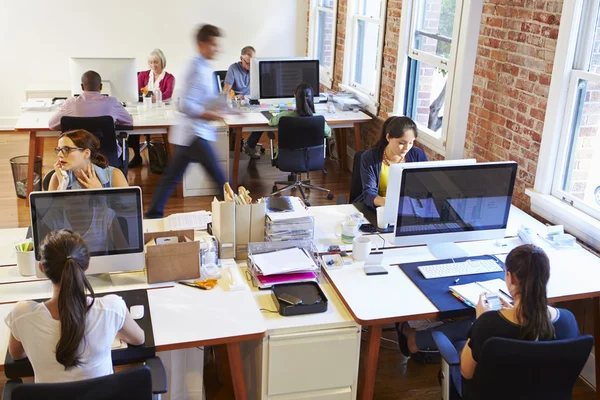 Oficina de diseño ocupado con los trabajadores en los escritorios — Foto de Stock