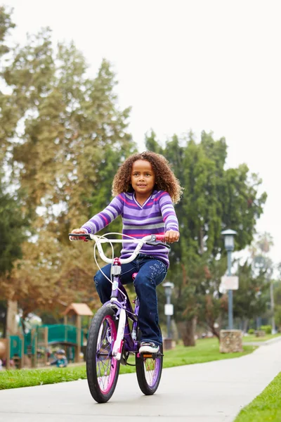 Junges Mädchen reitet Fahrrad im Park — Stockfoto