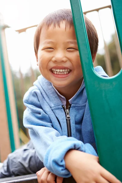 Menino no quadro de escalada no parque infantil — Fotografia de Stock