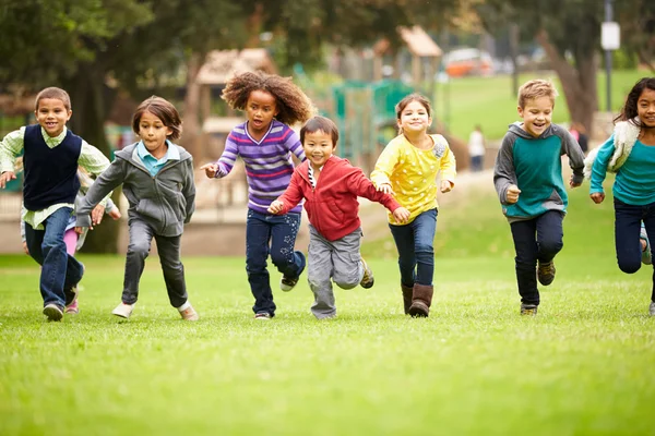 Группа детей, бегающих в парке — стоковое фото