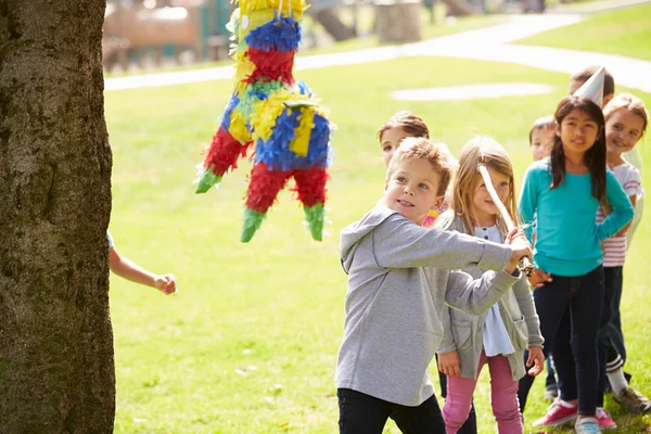 Niños golpeando piñata en fiesta de cumpleaños —  Fotos de Stock