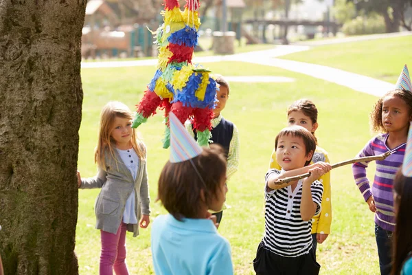 子供の誕生日パーティーでピニャータを打つ — ストック写真