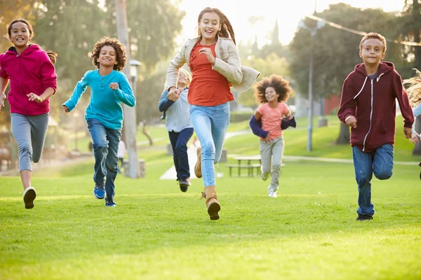 Puistossa juokseva lapsiryhmä — kuvapankkivalokuva