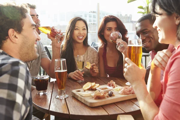 Amis appréciant les boissons et les collations dans le bar — Photo