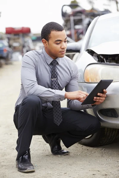 Verlies Adjuster tijdens auto wrak inspectie — Stockfoto