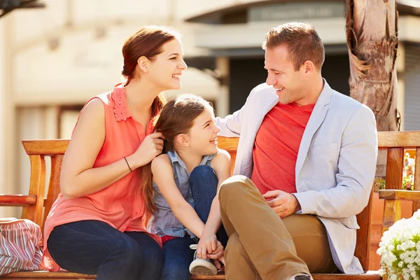 Giovane famiglia seduta sul banco — Foto Stock