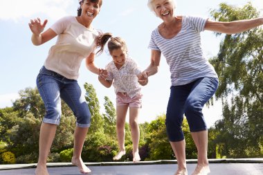 Grandmother, Granddaughter And Mother On Trampoline clipart
