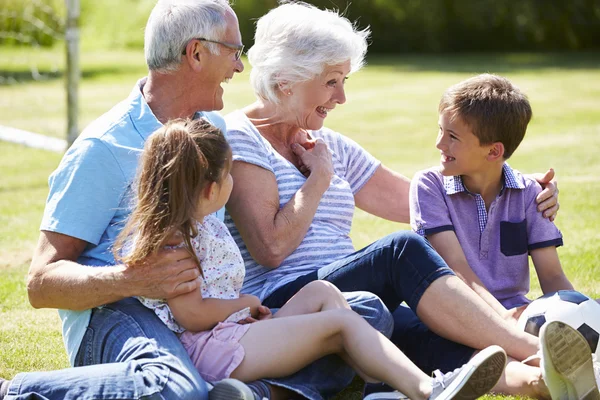 Großeltern und Enkel spielen Fußball im Garten — Stockfoto