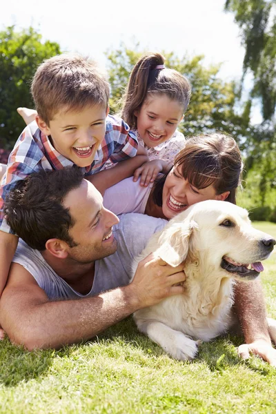 Familia relajante en el jardín con perro mascota — Foto de Stock