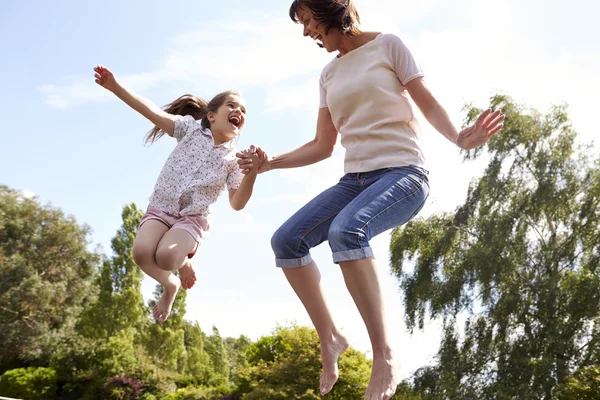 Mor och dotter studsande på studsmatta — Stockfoto