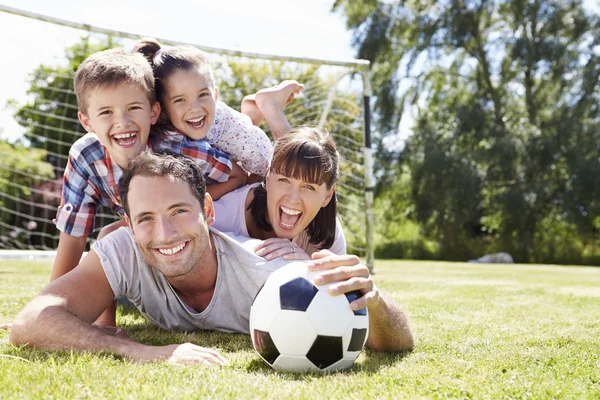 Familj spelar fotboll i trädgården — Stockfoto