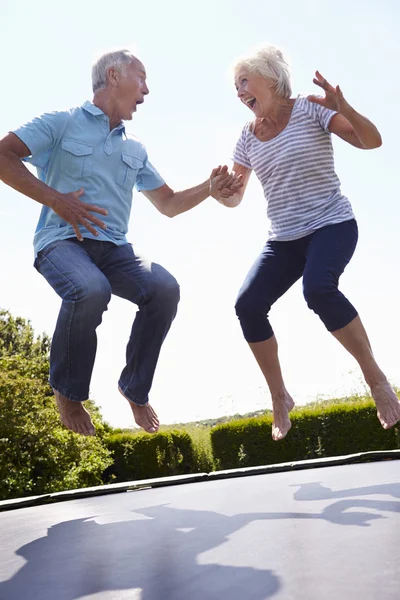 Pareja mayor rebotando en trampolín — Foto de Stock