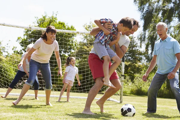 Multi geração jogando futebol no jardim — Fotografia de Stock