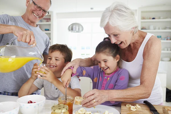 Abuelos con nietos haciendo el desayuno —  Fotos de Stock