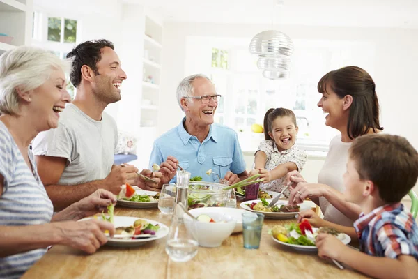 Family Eating Meal Around Kitchen Table