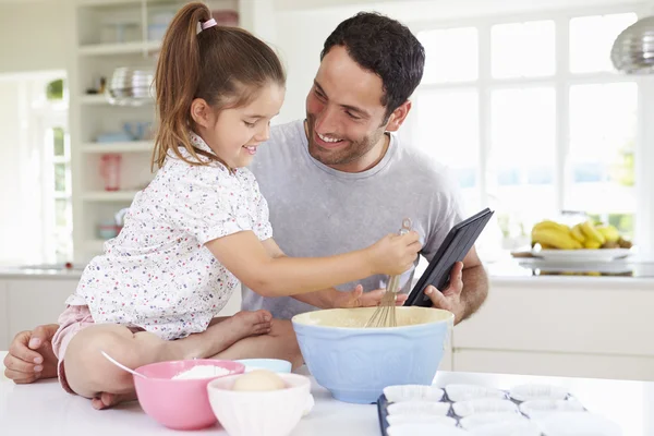 Padre e hija siguiendo receta de pastel —  Fotos de Stock