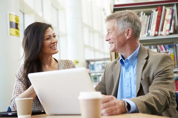 Insegnante aiutare maturo studente in biblioteca — Foto Stock