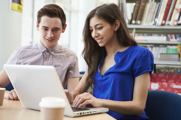 Dois estudantes usando laptop na biblioteca — Fotografia de Stock