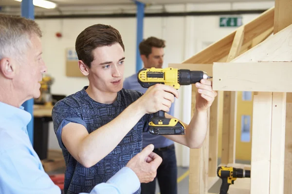 Учитель помогает студентам в изучении плотницкого дела — стоковое фото