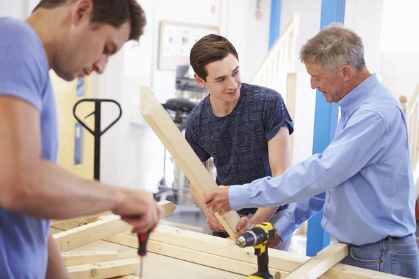 Учитель помогает студентам в изучении плотницкого дела — стоковое фото