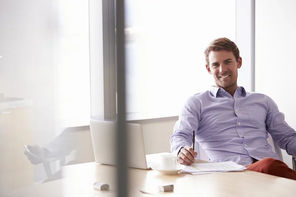 Empresário sentado à mesa — Fotografia de Stock