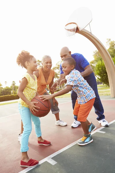Бабушка с дедушкой и внуки вместе играют в баскетбол — стоковое фото