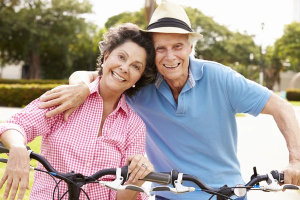 Pareja de ancianos montar bicicletas en el parque — Foto de Stock