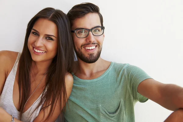 Portrait Of Couple Sitting Against White Wall — Stock Photo, Image